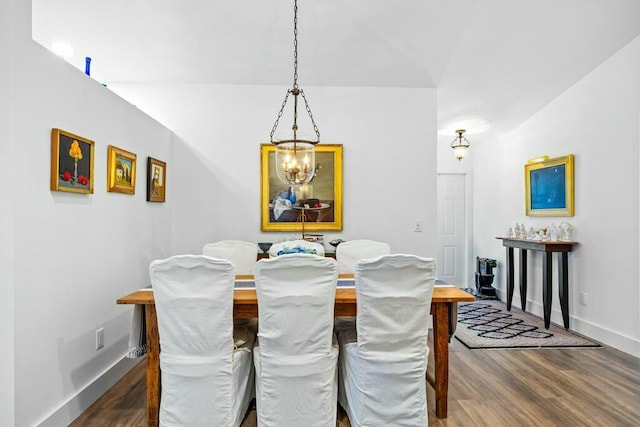 dining space with wood-type flooring and a chandelier