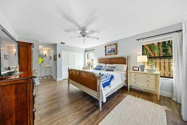 bedroom with ensuite bath, ceiling fan, and dark wood-type flooring