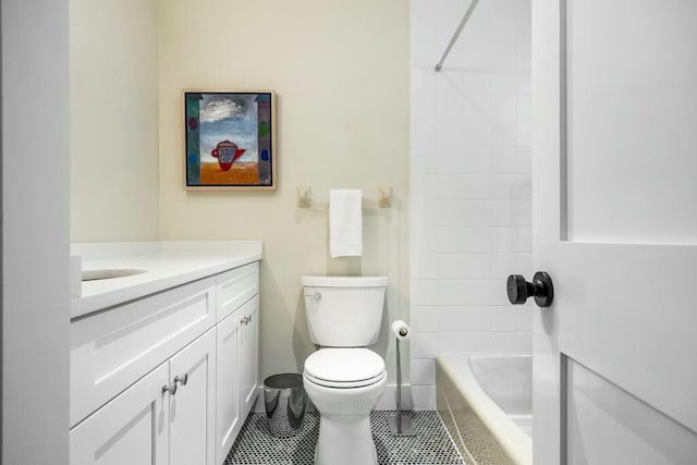 full bathroom featuring tile patterned floors, tiled shower / bath, vanity, and toilet