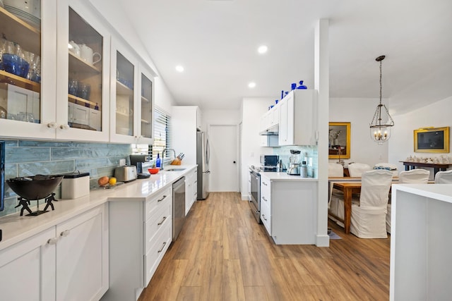 kitchen featuring decorative light fixtures, white cabinetry, and stainless steel appliances