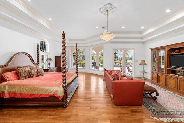 bedroom featuring a raised ceiling, crown molding, and light hardwood / wood-style floors