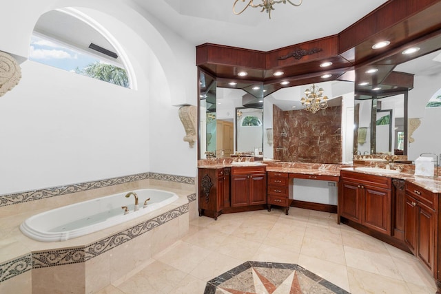 bathroom featuring tiled bath, vanity, and a chandelier