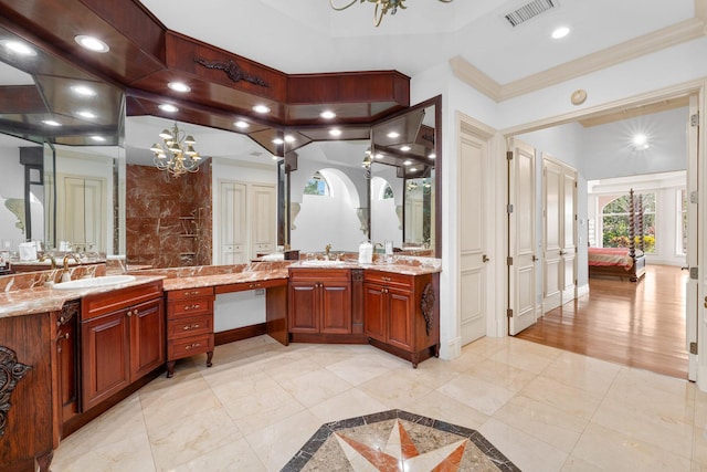 bathroom with a notable chandelier, ornamental molding, and vanity