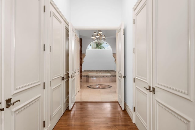 hallway with a chandelier and dark wood-type flooring