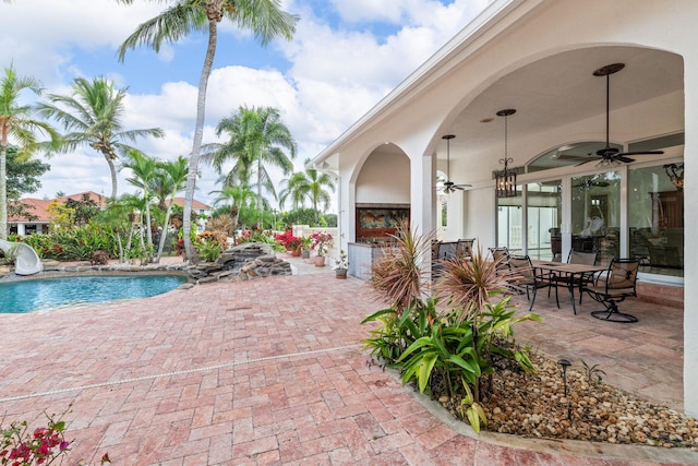 view of swimming pool featuring ceiling fan and a patio