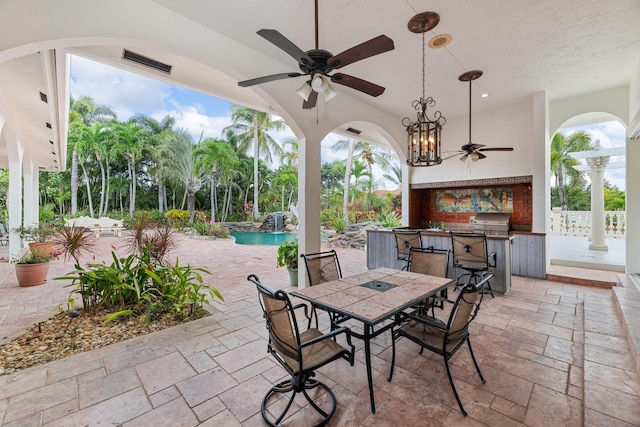 view of patio / terrace featuring area for grilling, ceiling fan, exterior kitchen, and an outdoor bar