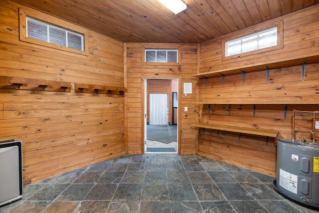 interior space featuring electric water heater, wooden ceiling, and wooden walls