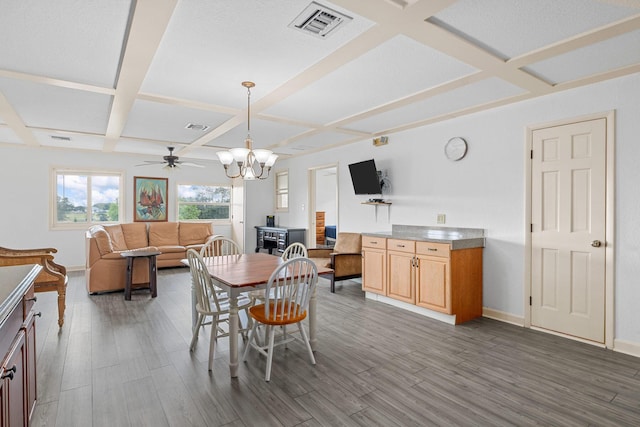 dining room with beamed ceiling, ceiling fan with notable chandelier, dark wood-type flooring, and coffered ceiling