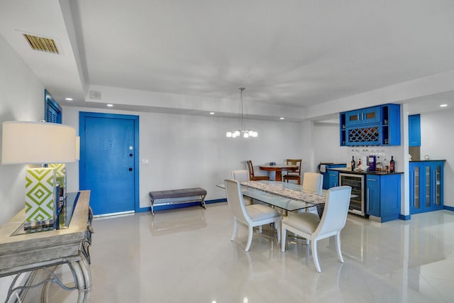 dining space with a chandelier, beverage cooler, and indoor bar