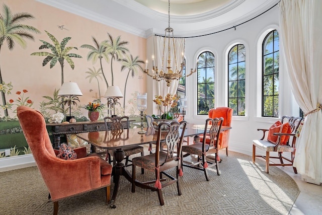 dining space with ornamental molding, a chandelier, and a tray ceiling