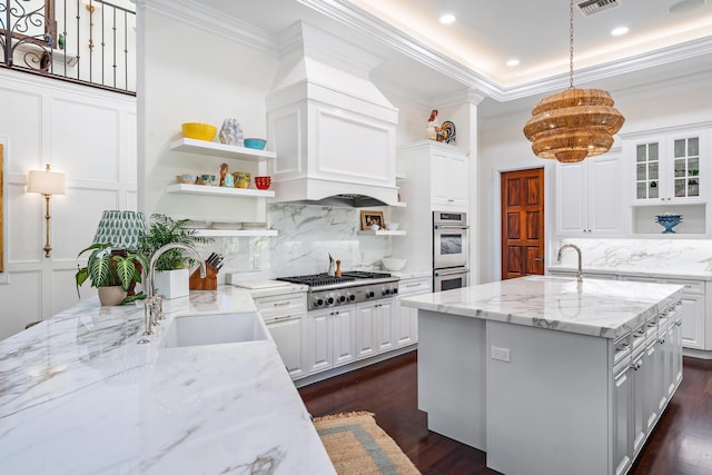 kitchen featuring white cabinetry, sink, pendant lighting, and light stone counters