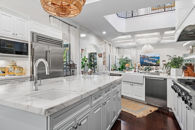 kitchen with a center island, sink, built in appliances, and white cabinets