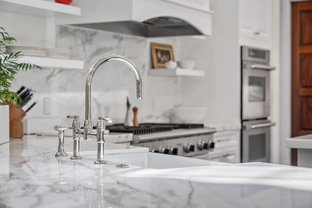 room details featuring exhaust hood, backsplash, and double oven