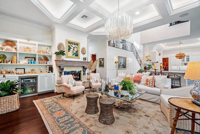 living room with dark hardwood / wood-style floors, beverage cooler, ornamental molding, coffered ceiling, and a notable chandelier