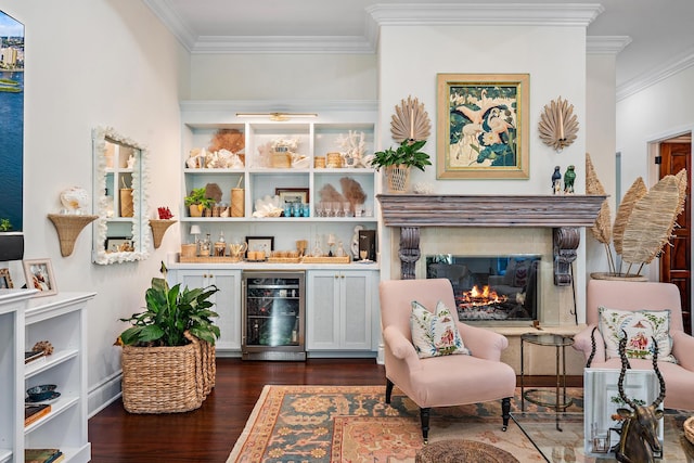 living area with crown molding, dark hardwood / wood-style floors, a fireplace, beverage cooler, and indoor bar