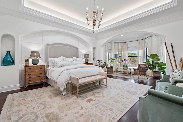 bedroom with a raised ceiling, crown molding, hardwood / wood-style floors, and an inviting chandelier