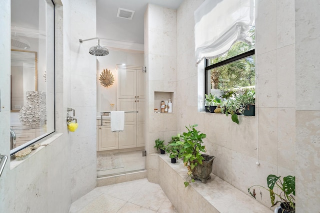 bathroom featuring tile patterned floors, vanity, and a tile shower