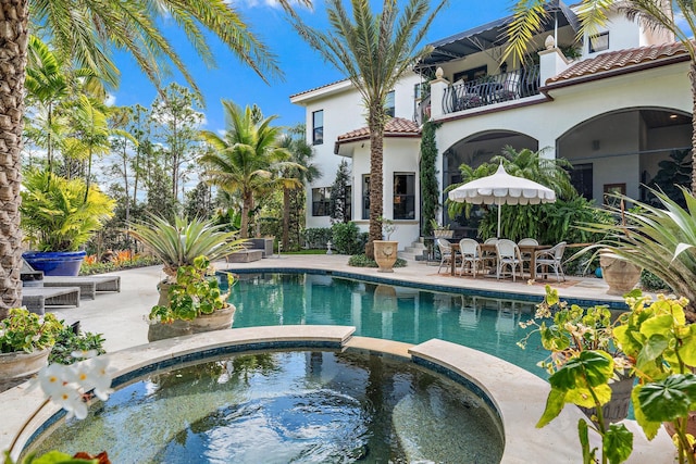 view of swimming pool with a patio area and an in ground hot tub