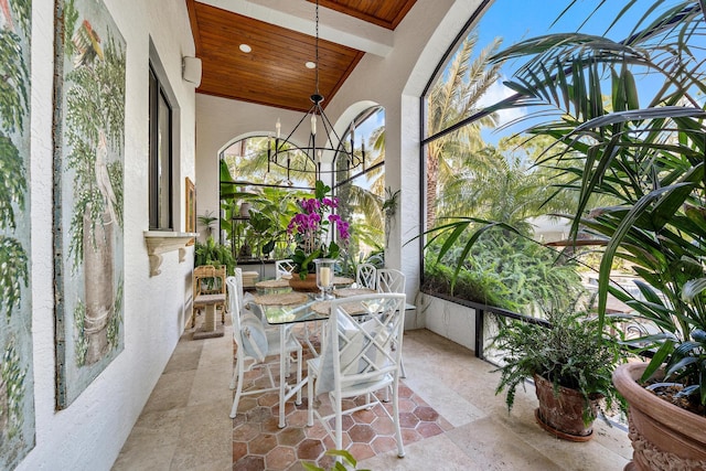 sunroom / solarium with a notable chandelier and wood ceiling