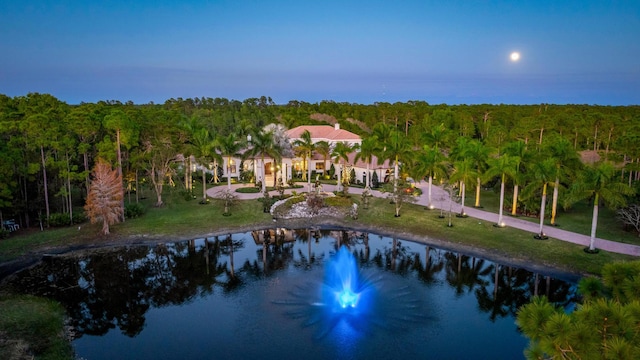 aerial view at dusk featuring a water view