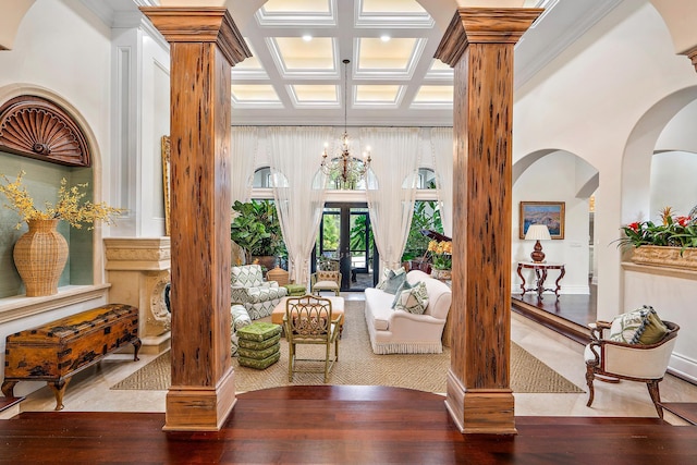 interior space featuring coffered ceiling, a notable chandelier, wood-type flooring, and decorative columns