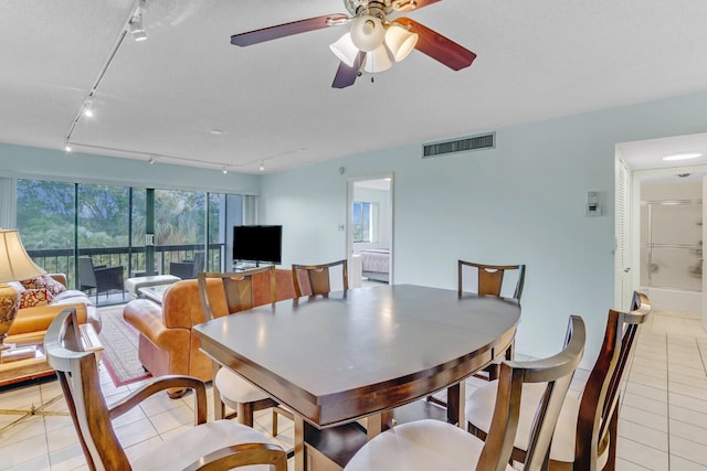 dining area with ceiling fan, light tile patterned floors, and rail lighting