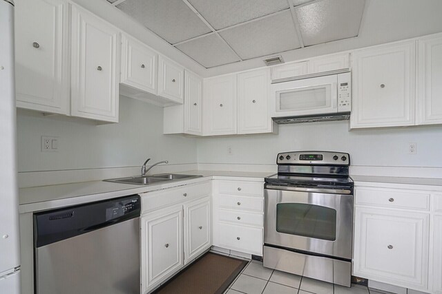 kitchen with white cabinetry, dishwasher, a drop ceiling, and sink