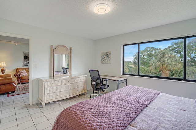 bedroom with light tile patterned flooring and a textured ceiling