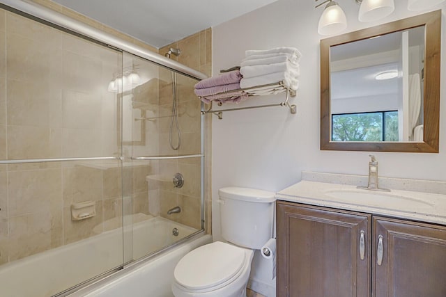 full bathroom featuring vanity, enclosed tub / shower combo, and toilet