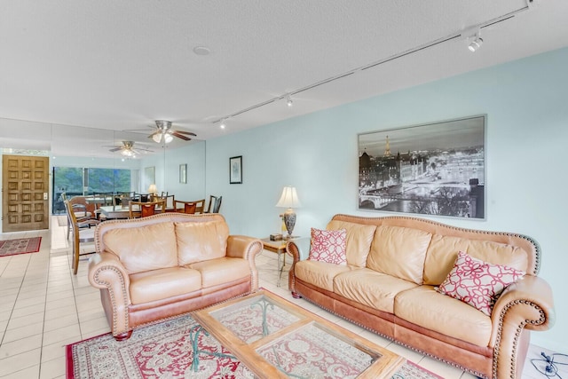 tiled living room featuring a textured ceiling and rail lighting