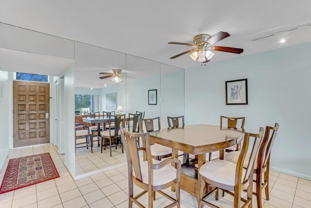 dining room with light tile patterned floors, a textured ceiling, and track lighting