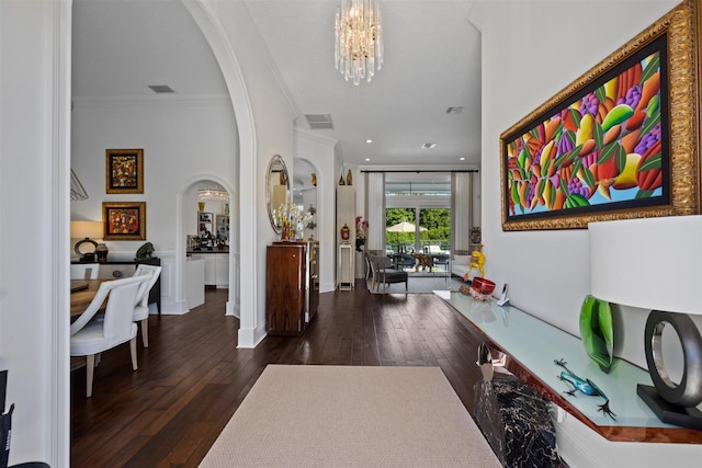 entryway with a textured ceiling, dark hardwood / wood-style flooring, an inviting chandelier, and crown molding