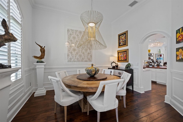 dining area with dark hardwood / wood-style floors, ornamental molding, and a chandelier