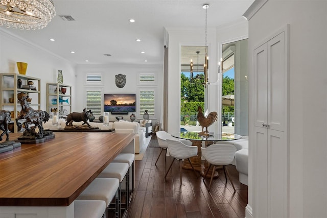 dining space with dark hardwood / wood-style floors, crown molding, and a chandelier