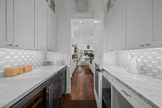 bar featuring white cabinets and light stone countertops