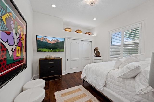 bedroom with dark wood-type flooring and a closet