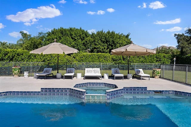 view of pool with a patio area and an in ground hot tub