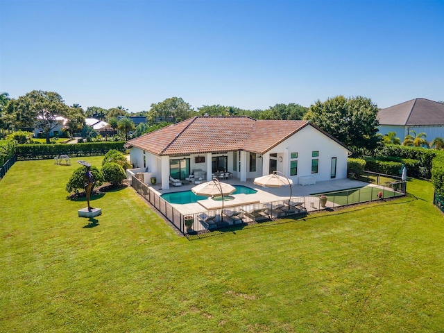 back of property featuring a yard, a fenced in pool, and a patio