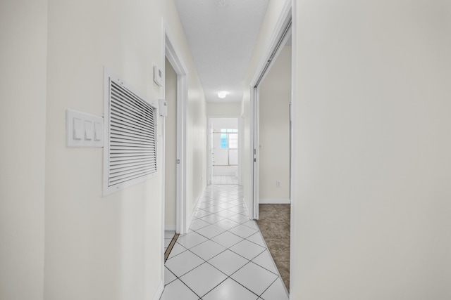 hall with light tile patterned floors