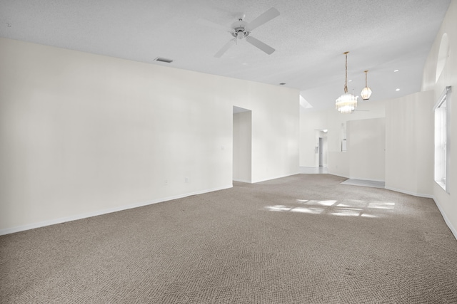 unfurnished room with a textured ceiling, carpet, vaulted ceiling, and ceiling fan with notable chandelier