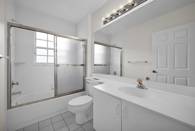 full bathroom with shower / bath combination with glass door, tile patterned flooring, vanity, and toilet