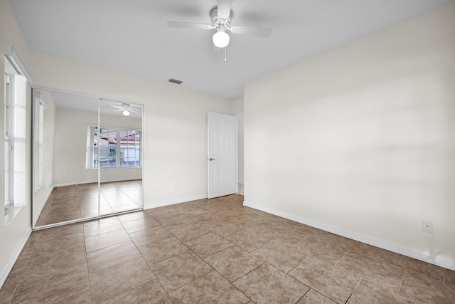 unfurnished bedroom featuring ceiling fan, light tile patterned flooring, and a closet