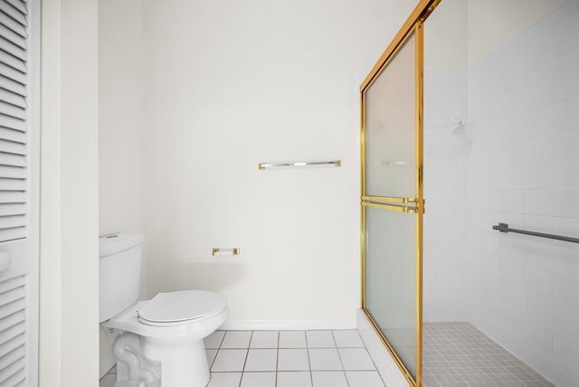 bathroom with tile patterned flooring, toilet, and a shower with door