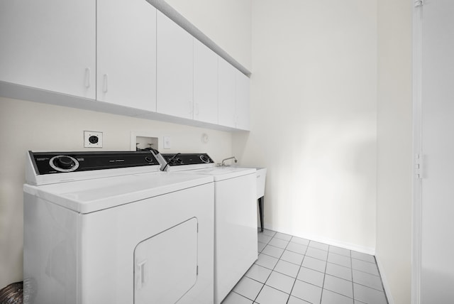 washroom featuring washer and clothes dryer, light tile patterned flooring, and cabinets