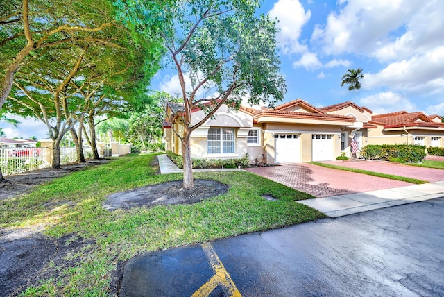 view of front of home featuring a garage and a front lawn