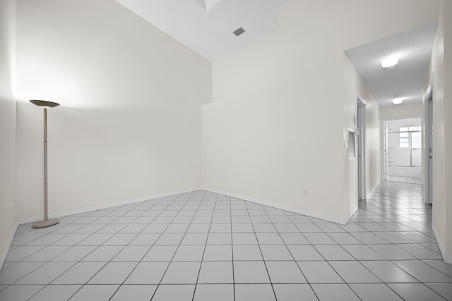 empty room featuring light tile patterned floors and vaulted ceiling