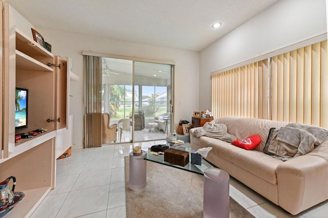 living room featuring light tile patterned floors, a textured ceiling, and ceiling fan