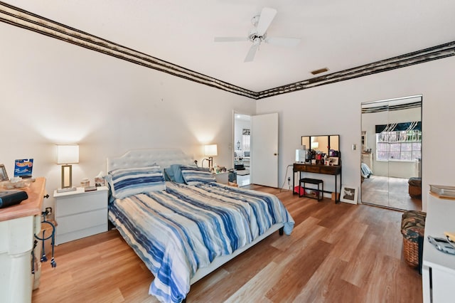 bedroom with hardwood / wood-style floors, ceiling fan, and crown molding