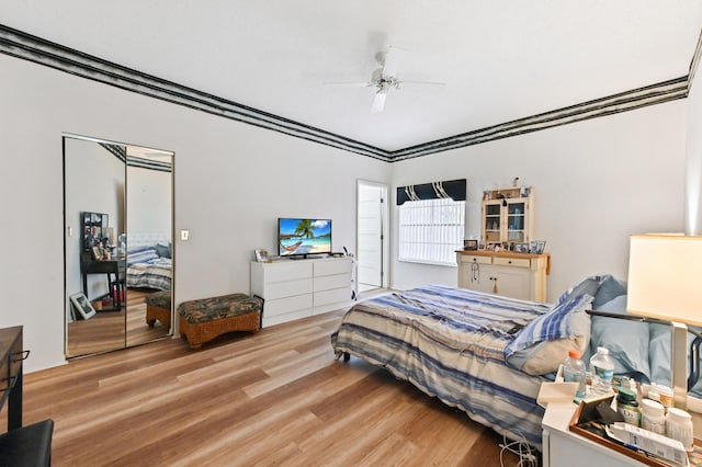 bedroom with light wood-type flooring, a closet, and ceiling fan