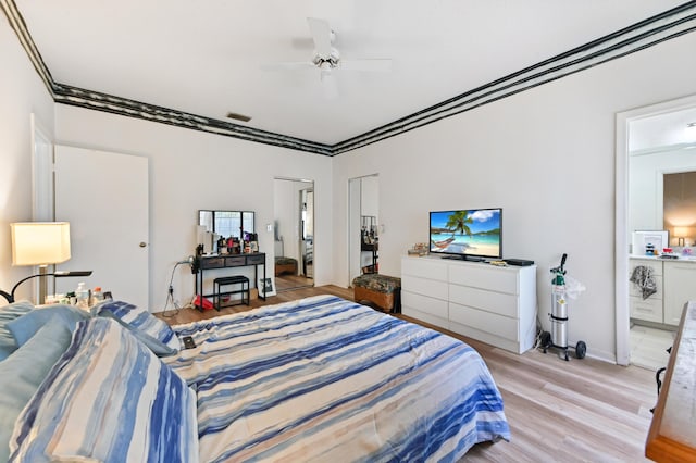 bedroom featuring ceiling fan, light wood-type flooring, and crown molding